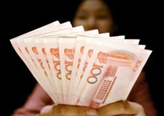 A clerk at an foreign currency exchange desk at a hotel shows Chinese yuan banknotes in Shanghai, China, in this July 22, 2005 file photo. China's official exchange rate rose Monday, May 14, 2006 to 7.9982 yuan per U.S. dollar, its highest level since a revaluation in July, the government said. (AP