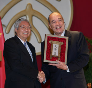 Peking University President Xu Zhihong (left) presents French President Jacques Chirac with a duplicate plaque of the university's predecessor, the Jing Shi Da Xue Tang or Metropolitan Grand University, yesterday. 