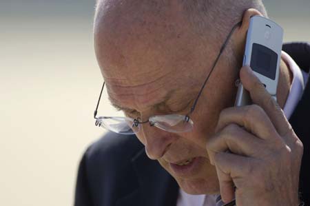 U.S. Treasury Secretary Henry Paulson talks on his mobile phone while waiting for China's Vice Premier Wu Yi to arrive at Andrews Air Force Base near Washington, May 21, 2007.
