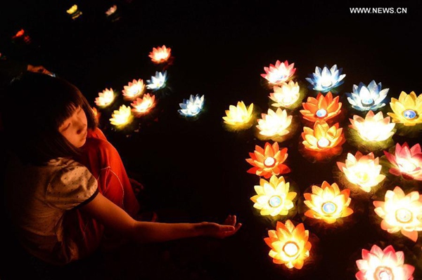 Mourners float river lanterns for the deceased