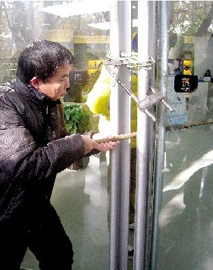 店员在玻璃门锁三把锁 小偷用长棍挑走电脑(图)