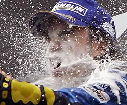 Renault's Formula One overall leader Fernando Alonso of Spain enjoys champagne after winning the German Formula One Grand Prix, his sixth victory in this year's Formula One season, at the Hockenheim race track, July 24, 2005. Alonso won the race ahead of William's Juan Pablo Montoya of Colombia and Honda's Jenson Button of Great Britain.