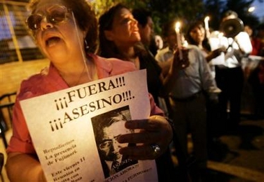Protesters hold candles and shout slogans against former Peruvian President Alberto Fujimori outside the police training academy in Santiago, Chile, Thursday, Nov. 10, 2005, where Fujimori is being held since he was detained on an international arrest warrant after arriving on Sunday.