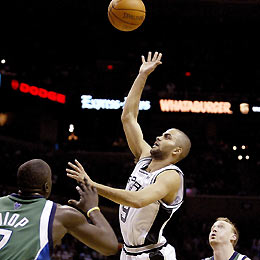 San Antonio Spurs guard Tony Parker (C) goes to the hoop against Dallas Mavericks center DeSagana Diop (L) and forward Keith Van Horn in the first half during their NBA game in San Antonio, Texas, March 2, 2006.