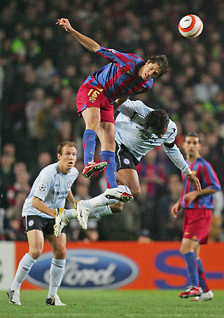 Chelsea's Didier Drogba (2nd R) and Barcelona's Edmilson (2nd L) jump for the ball as Arjen Robben (L) watches during their Champions League first knockout round return leg soccer match at the Nou Camp stadium, Barcelona March 7, 2006. [Reuters]