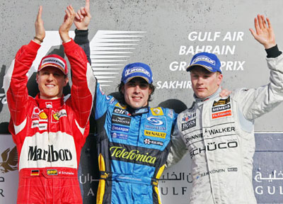 Winner of the Bahrain Formula One Grand Prix Renault's Fernando Alonso of Spain (C) celebrates with Ferrari's Michael Schumacher of Germany (L) and McLaren's Kimi Raikkonen of Finland on the winners podium at the Sakhir racetrack in Manama March 12, 2006. [Reuters]