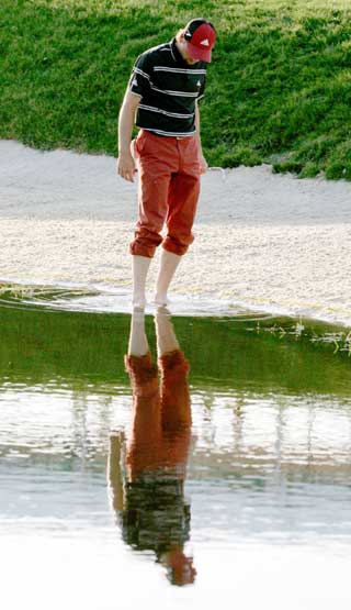 Sergio Garcia of Spain enters the water on the 17th hole before hitting during the third round of the Bay Hill Invitational PGA golf tournament in Orlando, Florida, March 18, 2006. Garcia scored a bogey four on the hole and finished the round eight-under-par for the tournament with a 208 total