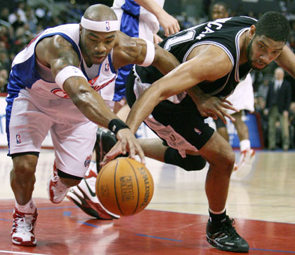 San Antonio Spurs Tim Duncan (R) and Los Angeles Clippers Corey Maggette fight for a loose ball during the first quarter of NBA action in Los Angeles, March 28, 2006. 