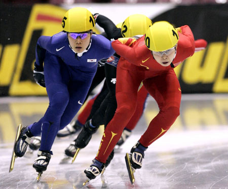 Meng Wang of China (R) and Eun-Kyung Choi of South Korea (L) battle for position during a preliminary heat of the Women's 1500 meter race of the World Short Track Championships at Mariucci Arena in Minneapolis, March 31, 2006. Wang finished first while Choi finished second. [Reuters]