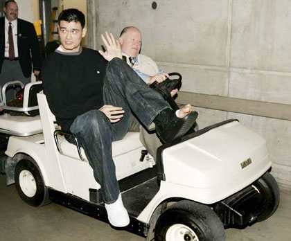 Houston Rockets center Yao Ming, of China, is driven from the arena locker room by security director Al Higham after his NBA basketball game against the Utah Jazz on Monday, April 10, 2006, in Salt Lake City. Yao broke his left foot in the first quarter. The Jazz beat the Rockets, 85-83. (AP 