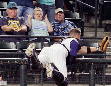 Arizona Diamondbacks catcher Chris Snyder reaches over the rail but misses a foul ball during the eighth inning against the San Francisco Giants in Major League Baseball action in Phoenix, Arizona, April 17, 2006. San Francisco won 10-9. 