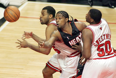 Miami Heat forward Udonis Haslem (C) puts up a shot between Chicago Bulls forwards Malik Allen (L) and Michael Sweetney in the first quarter of their NBA Eastern Conference quarterfinal game in Chicago April 27, 2006. 