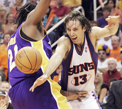 Phoenix Suns guard Steve Nash (R) of Canada passes to a teammate while being guarded by Los Angeles Lakers forward Ronny Turiaf in the final minutes of Game Seven of their NBA Western Conference Playoff series in Phoenix, Arizona May 6, 2006. The Suns defeated The Lakers 121-90 advancing to the second round and will play the Los Angeles Clippers beginning May 8 in Phoenix. 