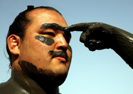 A Japanese sumo wrestler has mud applied to his face during a visit to the Dead Sea June 8, 2006. A team of Japan's and the world's top sumo wrestlers arrived in Israel on Sunday for a six-day visit. [Reuters]