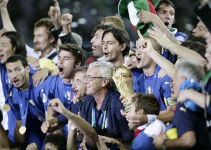 Italy coach Marcello Lippi poses with his team officials and players as captain Fabio Cannavaro holds the World Cup Trophy after the World Cup 2006 final soccer match between Italy and France in Berlin July 9, 2006.