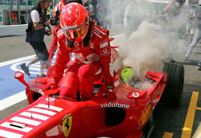 German Formula One driver Michael Schumacher leaves his Ferrari as it catches fire during the third practice session of the French Grand Prix at the Magny-Cours circuit July 15, 2006. 