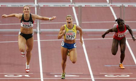 Sweden's Susanna Kallur (C) crosses the finish line to win the gold medal in the women's 100 m hurdles ahead of bronze medallist Kirsten Bolm of Germany (L) and Spain's Glory Alozie at the European athletics championships in Gothenburg (Goteborg), August 11, 2006. 