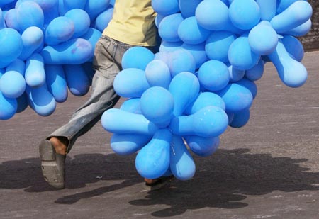 A balloon seller runs with his balloons during the start of 'Delhi Half Marathon 2006' in New Delhi October 15, 2006. 