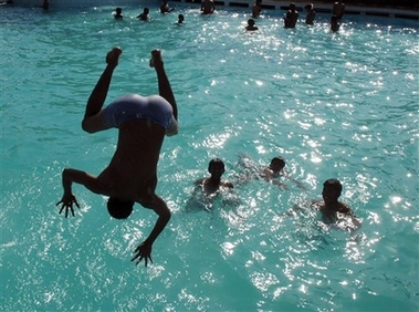 A boy dives into a pool to cool himself from the heat in Hyderabad, India, Wednesday, May 16, 2007. Scorching summer heat has engulfed most parts of southern India with temperatures touching 44 degrees Celsius (111 Fahrenheit). (AP Photo/Mahesh Kumar A) 