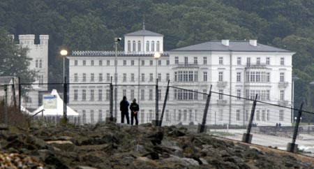 Visitors stand at the security fence in front of the venue for the upcoming G8 summit at the eastern German Baltic Sea resort of Heiligendamm June 3, 2007. German police clashed with hundreds of protesters in the port of Rostock on June 2, 2007 following a much larger peaceful demonstration against next week's Group of Eight summit in the nearby Baltic resort of Heiligendamm, injuring several hundreds of police officers, police said. 