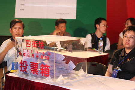Notary officials and residents' representatives wait to count the votes after a voting on the housing demolition and compensation policy at Jiuxianqiao sub-district in Chaoyang District of Beijing, June 9, 2007. Some 3,711 families, about 57% of the 5,473 families, cast their votes on Saturday, with 2,451 votes for and 1,228 votes against the demolition and compensation plan. Thirty-two votes were invalid.