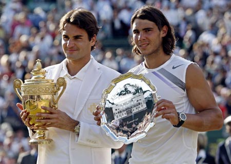 Switzerland's Roger Federer (L) holds the winners trophy as Spain's Rafael Nadal holds the runners-up trophy after the men's final at the Wimbledon tennis championships in London, July 8, 2007. 