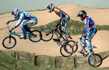 Competitors ride over the course during the UCI BMX Supercross World Cup at Laoshan Bicycle Moto Cross (BMX) venue in Beijing August 21, 2007.[Xinhua]