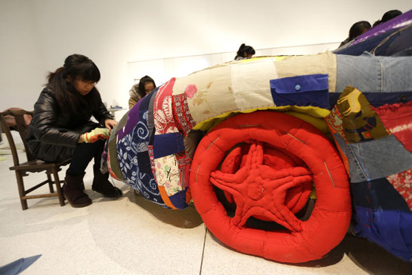 Women sew art work based on sports car in Beijing