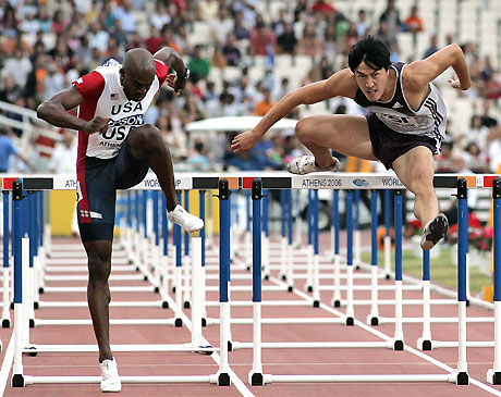 World record holder Liu Xiang(R) and Allen Johnson clear a hurdle at the men's 110-meter hurdles race of the IAAF World Cup in Athens on September 17, 2006. Liu finished second as Johnson won the race.[Xinhua]