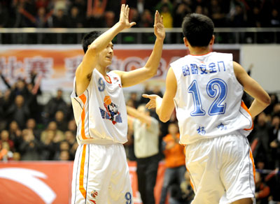 Zhang Qingpeng (L) and Yang Ming of the Liaoning Hunters celebrate after scoring a point during a game against the Guangdong Horses in the Chinese Basketball Association (CBA) Finals. Liaoning beat Guangdong 105-96. [Xinhua]