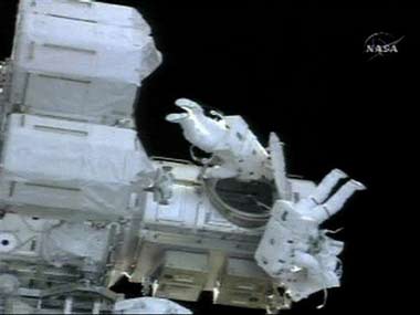 In this image made from NASA TV, astronaut Mike Fossum, left, and astronaut Piers Sellers, right with stripes, enter the Quest airlock after a spacewalk Saturday, July 8, 2006. (