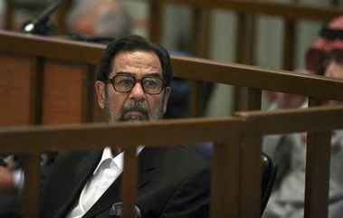 Former Iraqi leader Saddam Hussein listens to the proceedings during his ongoing trial inside the heavily fortified Green Zone in Baghdad, Iraq October 31, 2006. 