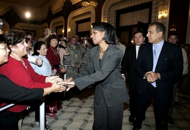 U.S. Secretary of State Condoleezza Rice, center, is saluted by the US embassy staff as Zalmay Khalilzad, right, the U.S. ambassador to Iraq, walks alongside her in Baghdad, Iraq, Saturday, Feb. 17, 2007.
