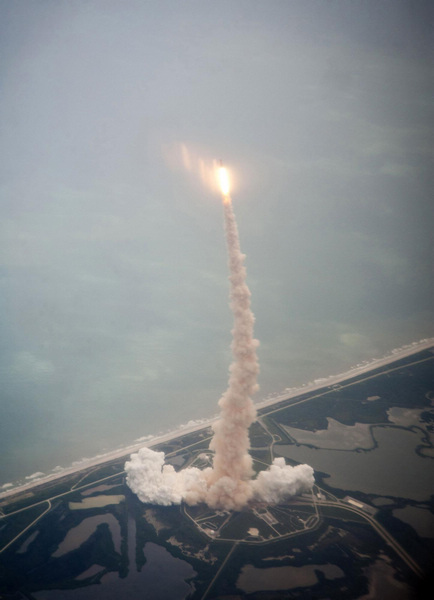 Space Shuttle Atlantis is seen through the window of a Shuttle Training Aircraft as it launches from pad 39A at the Kennedy Space Center July 8, 2011. NASA's last space shuttle blasts into history